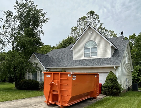 Contractor loading roofing debris into dumpster in Georgetown, KY