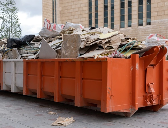 Contractor loading construction debris into rental dumpster in Winchester, KY