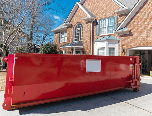 Professional construction dumpster rental team unloading a dumpster in Nicholasville